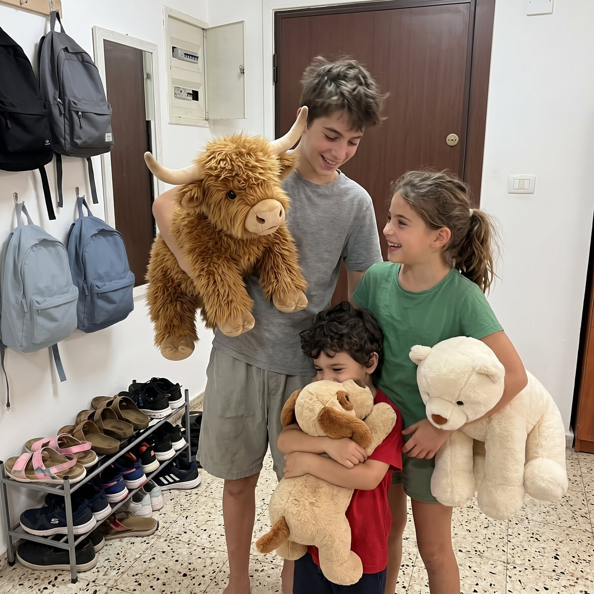 שלושה אחים במסדרון, כל אחד מחבק בובה: שוקו, פולי ואפה